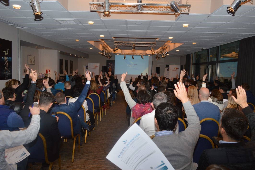 La salle d'une conférence Eagle Academy, mains levées
